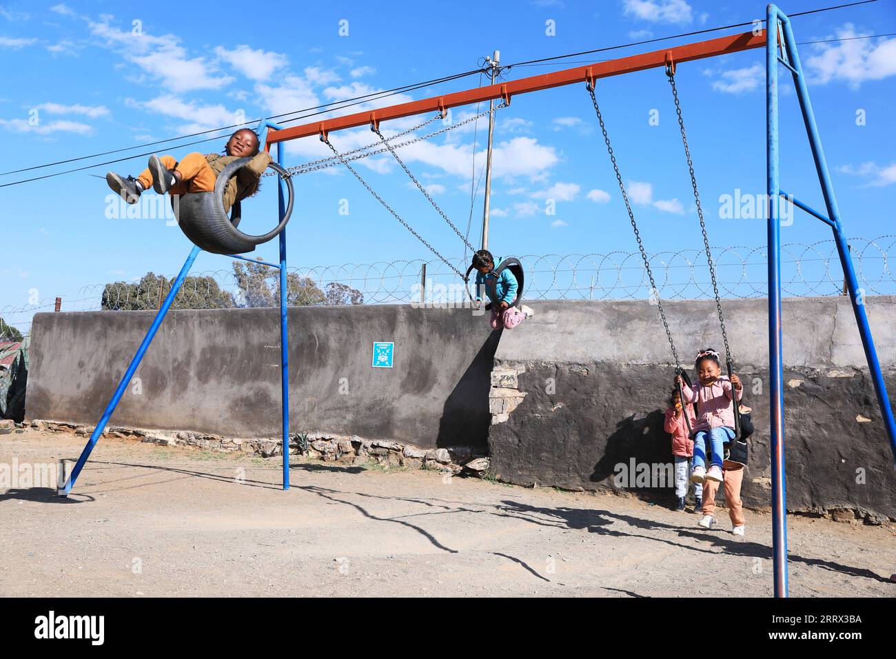 230817 -- CAPE TOWN, Aug. 17, 2023 -- Children play on swings at an early learning center in De Aar Town, more than 750 kilometers northeast of Cape Town, South Africa, on Aug. 11, 2023. This early learning center was funded by Longyuan South Africa Renewables of China Longyuan Power Group Corporation Limited, which has funded the establishment of four early learning centers in De Aar to provide education for children from poor families. Nearly 500 children in need have been admitted to these learning centers so far.  SOUTH AFRICA-DE AAR-CHINA-EARLY LEARNING CENTER DongxJianghui PUBLICATIONxNO Stock Photo