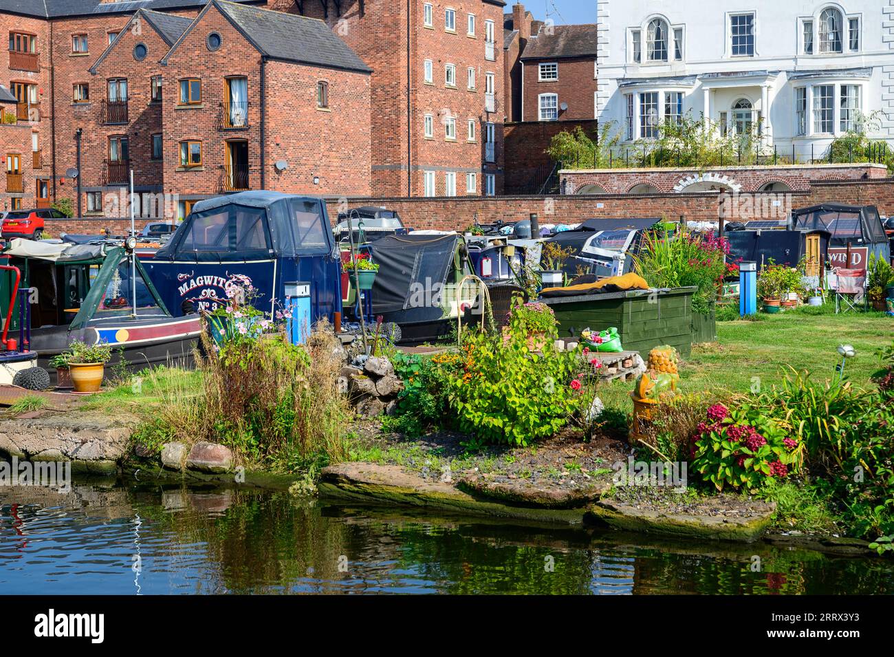 Narrowboats moored in front of the old and new houses that surround the canal basin in Stourport Upon Severn in Worcestershire. Stock Photo