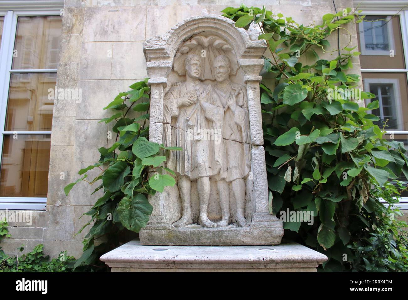Carved stone statue depicting two wise men in classical attire here located in the beautiful town of Châteauroux in rural central france. Stock Photo