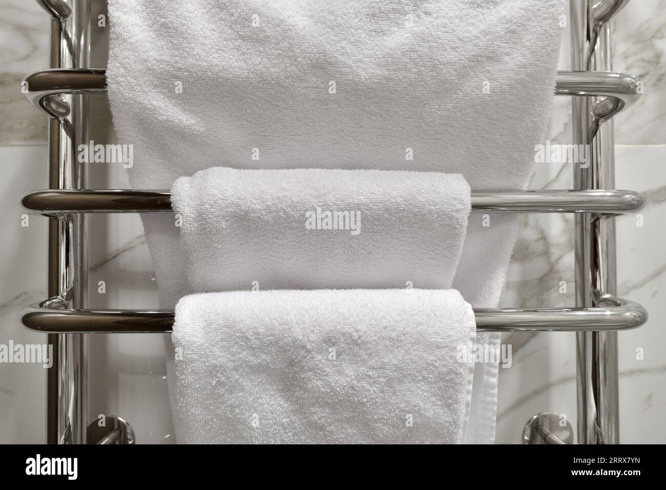 White terry towels hanging on heated towel rail in the bathroom Stock ...