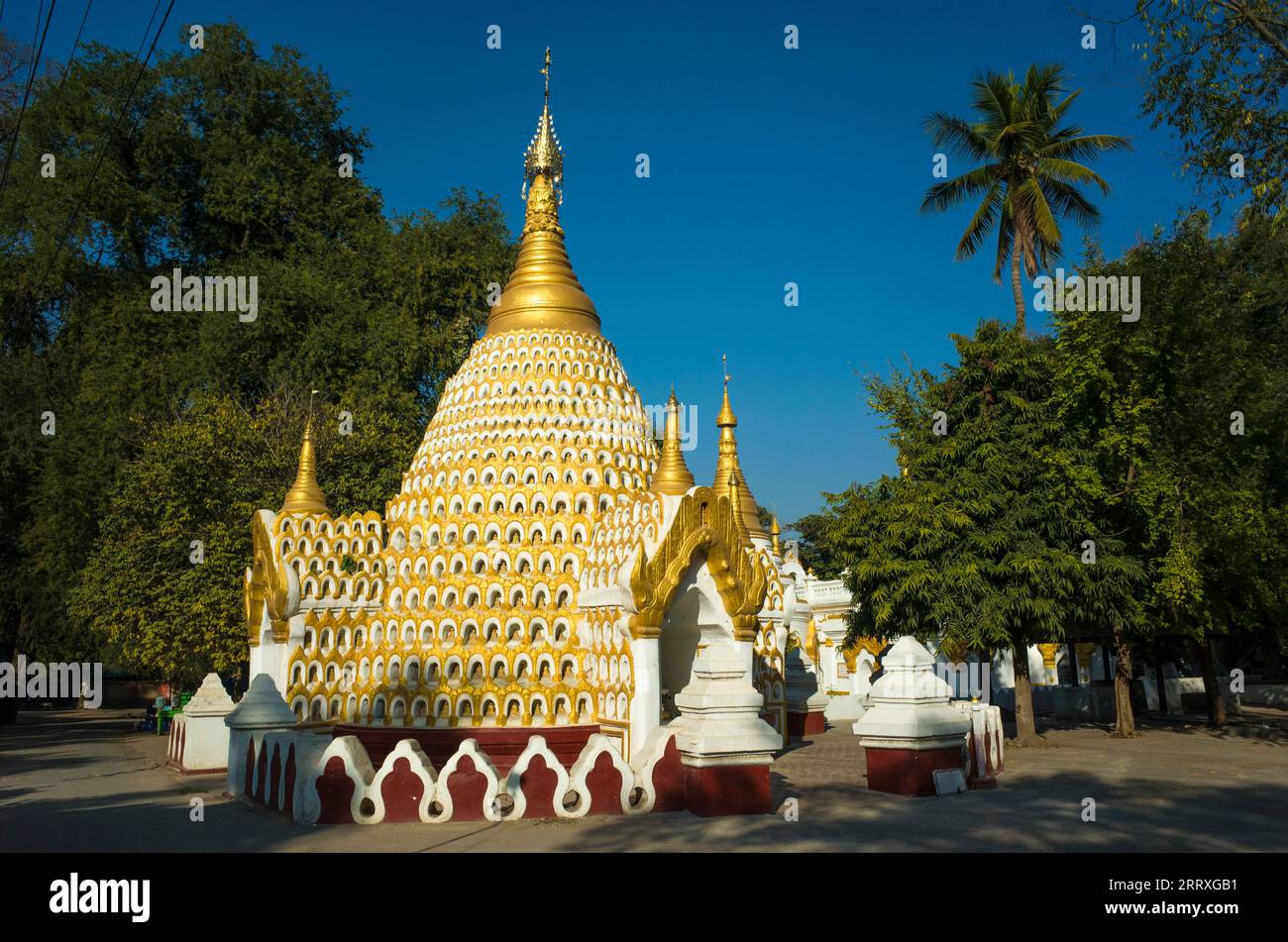 Buddhist pagoda decorated with thousand small Buddha sculptures meditating in caves. Amarapura, Mandalay, Myanmar Stock Photo