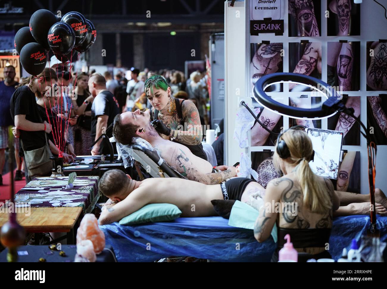 Berlin, Germany. 09th Sep, 2023. Armelle Vhen from Death Ray Studio in Nottingham, UK, tattoos a young man's neck during the 31st Tattoo Convention at Arena Berlin. Credit: Soeren Stache/dpa/Alamy Live News Stock Photo