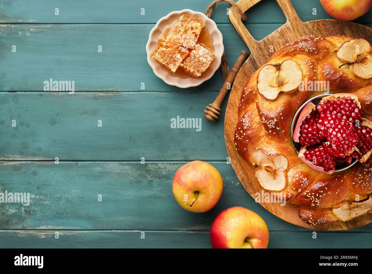 Jewish Holidays - Rosh Hashanah or Rosh Hashana. Pomegranate, apples, honey and round challah on old wooden blue table background. Jewish Autumn celeb Stock Photo