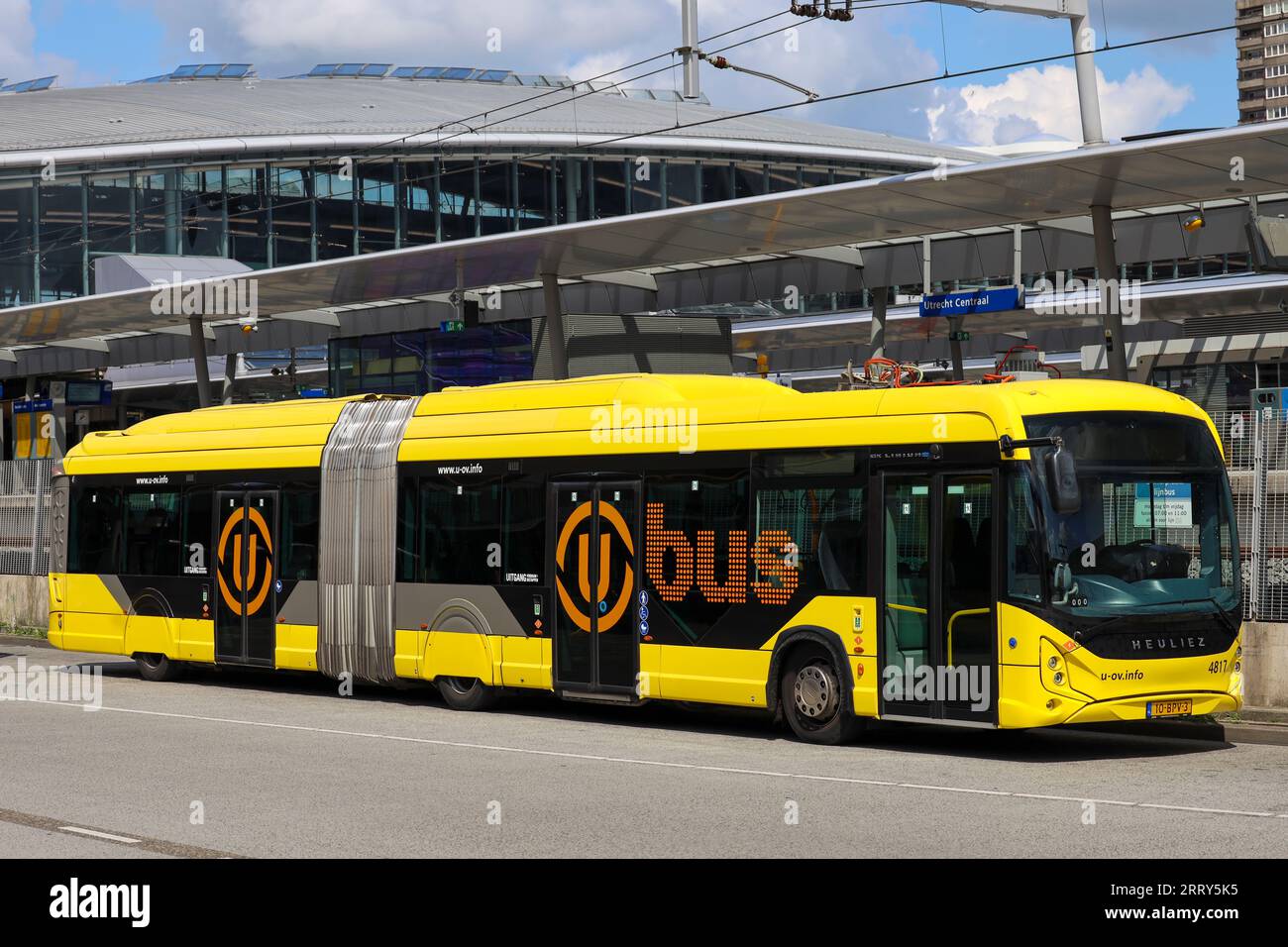 Articulated city bus in yellow colour of UOV in the city of Utrecht runned by QBUZZ in the