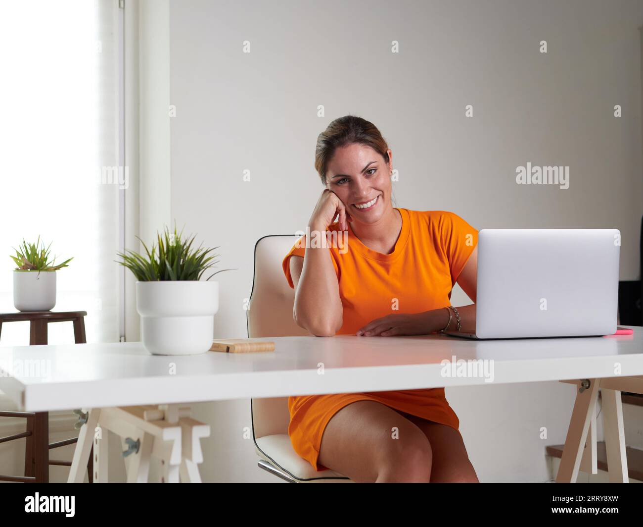 smiling woman working at home with laptop Stock Photo