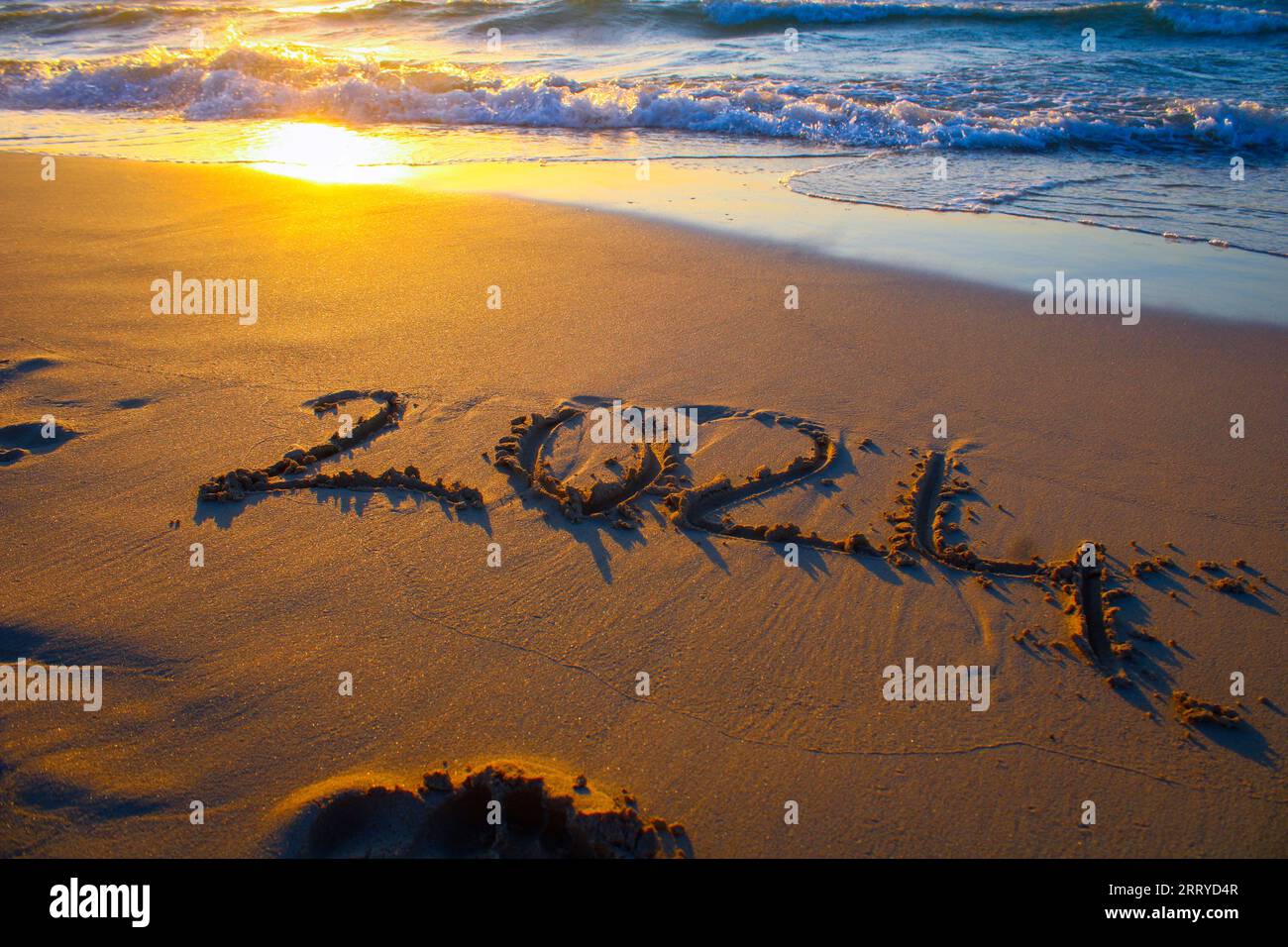 The number 2024 written in the sand on the beach. new year 2024 concept