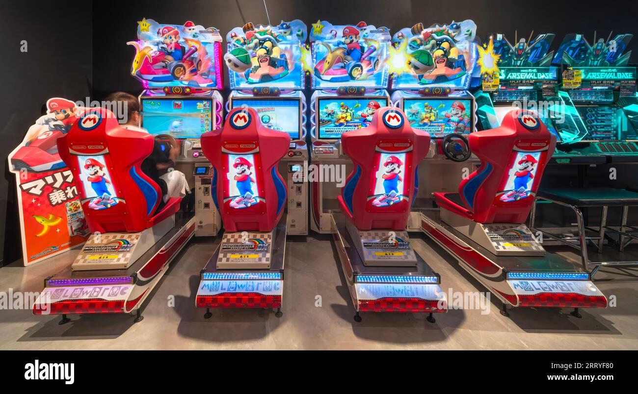 tokyo, japan - aug 22 2023: Illuminated e-sports seats lined up with a seated player playing the Mario Kart Arcade GP DX game developed by Nintendo an Stock Photo