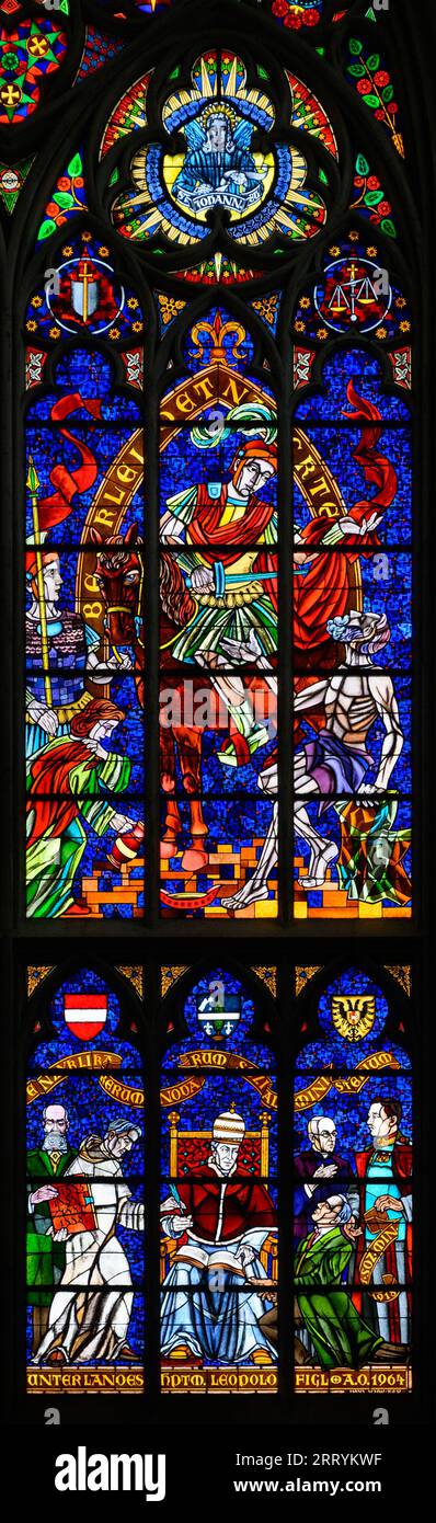 Stained-glass window depicting Catholic social reform, above Saint Martin of Tours, below Pope Leo XIII. Votivkirche – Votive Church, Vienna, Austria. Stock Photo