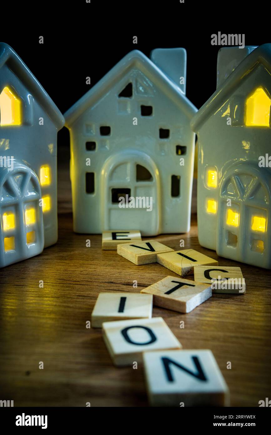 eviction sign in wooden letters leading to ceramic house with light off housing crisis estate agency homeless crisis Stock Photo