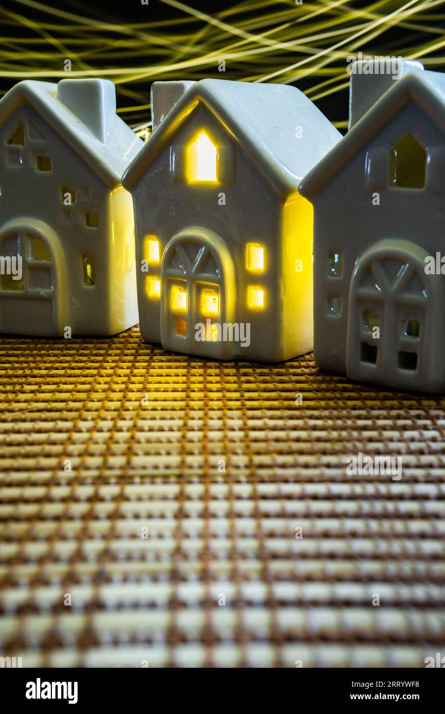 ceramic houses, one with light on housing crisis concept property ...