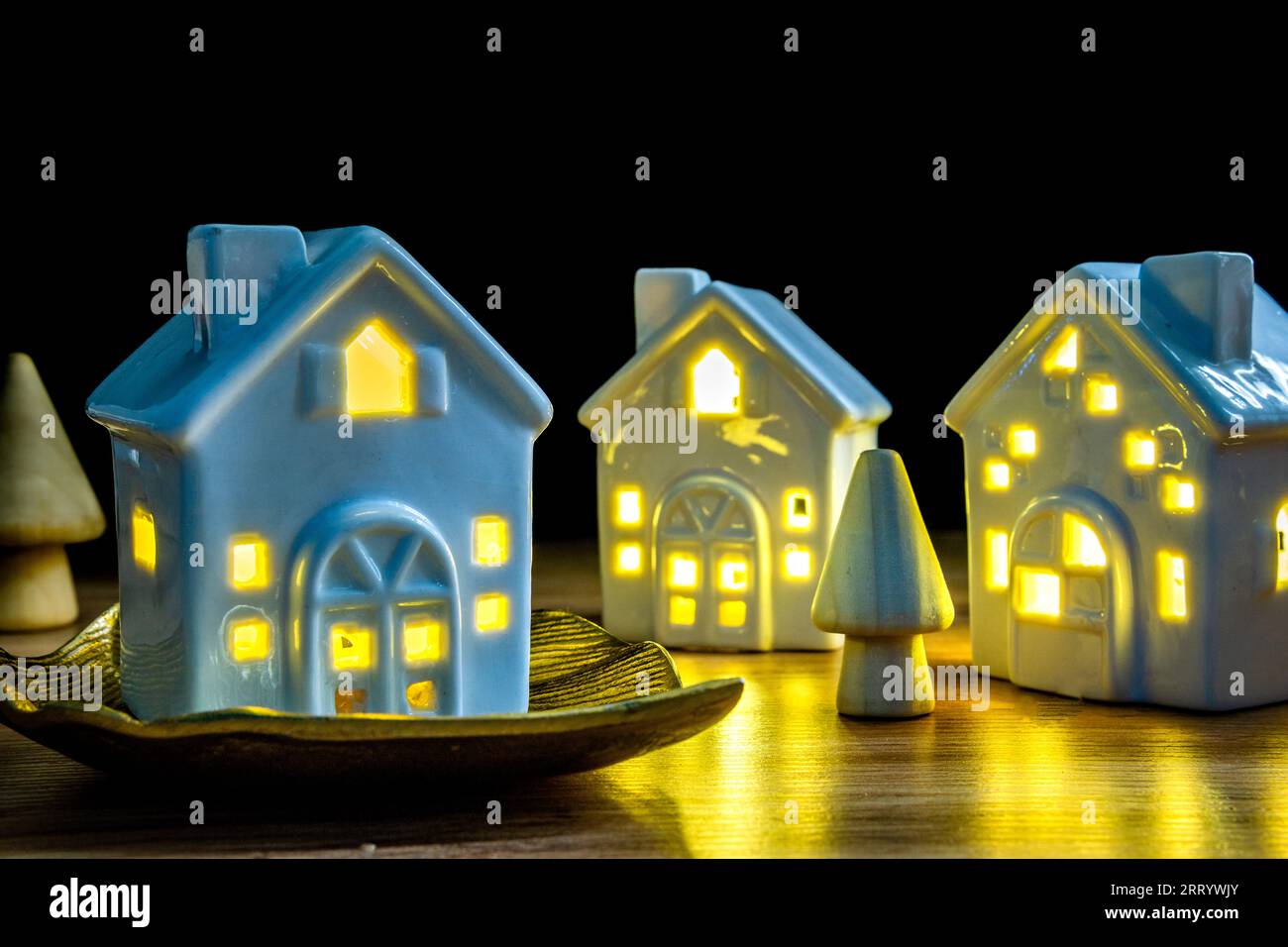 ceramic houses with light on housing crisis property ownership concept Stock Photo