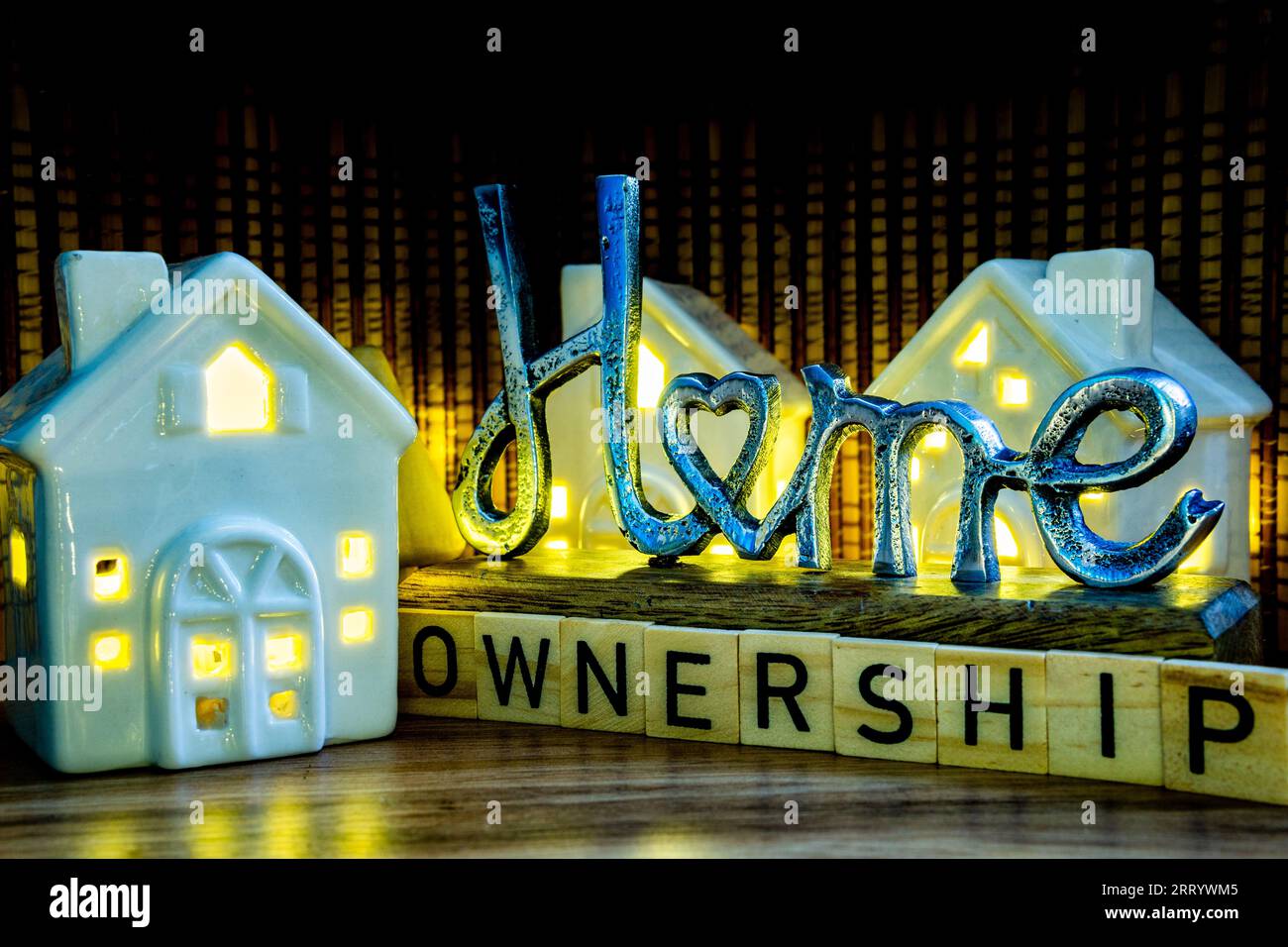 home ownership sing with ceramic houses with light on, buying house from an agent housing crisis concept illustration Stock Photo