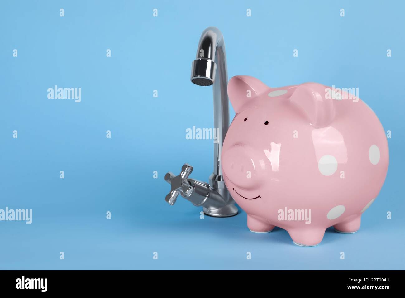 Water scarcity concept. Piggy bank and tap on light blue background ...