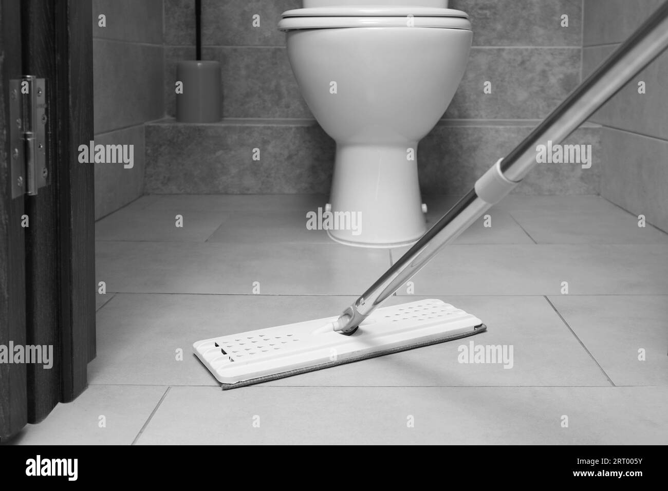 Cleaning grey tiled floor with mop in toilet Stock Photo Alamy