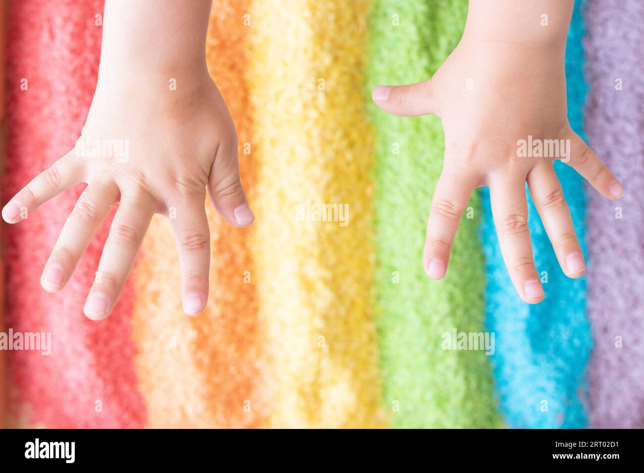 Kids hands in a sensory rice bin Stock Photo