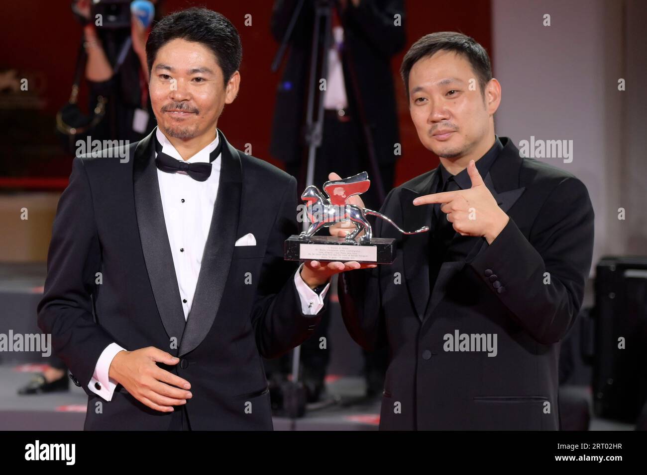Venice Lido, Italy. 09th Sep, 2023. Hitoshi Omika (l) and Ryûsuke Hamaguchi (r) pose with the Silver Lion Grand Jury Prize Award for 'Evil Does Not Exist' at the winner's photocall at the 80th Venice International Film Festival. Credit: SOPA Images Limited/Alamy Live News Stock Photo