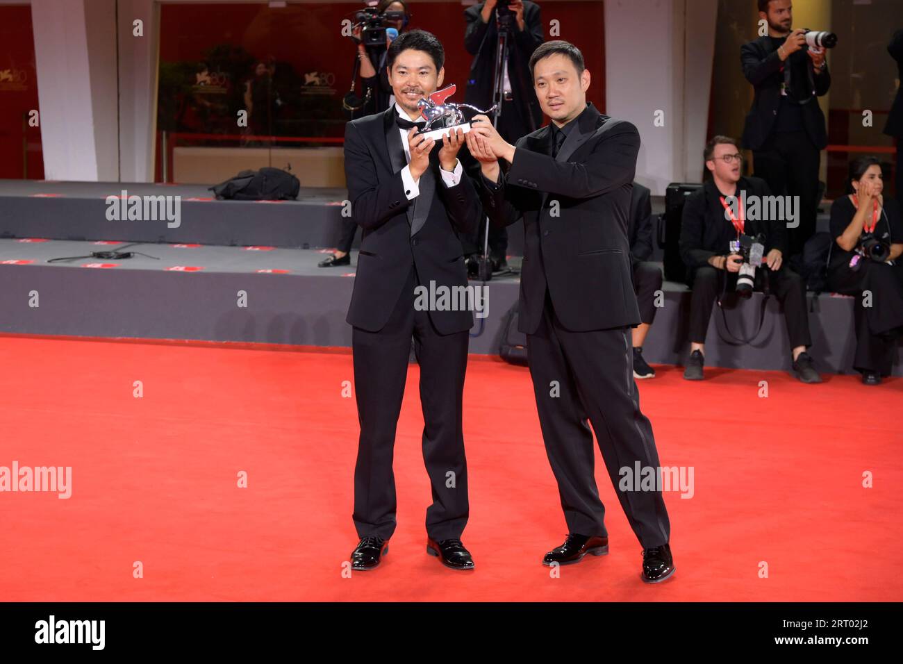 Venice Lido, Italy. 09th Sep, 2023. Hitoshi Omika (l) and Ryûsuke Hamaguchi (r) pose with the Silver Lion Grand Jury Prize Award for 'Evil Does Not Exist' at the winner's photocall at the 80th Venice International Film Festival Credit: SOPA Images Limited/Alamy Live News Stock Photo