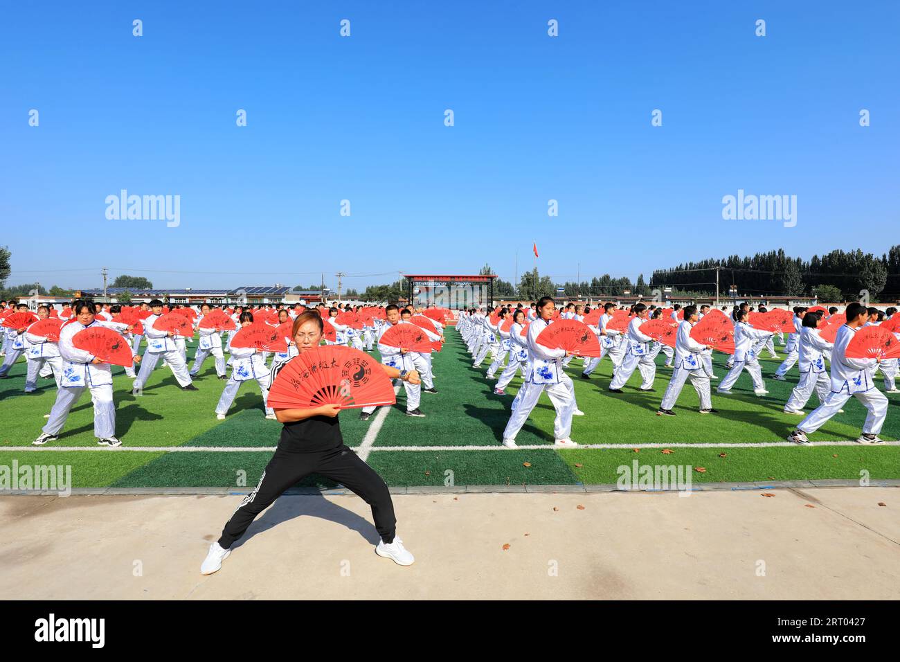 LUANNAN COUNTY, Hebei Province, China - September 30, 2020: Middle school students practice Taiji Fan on the playground Stock Photo