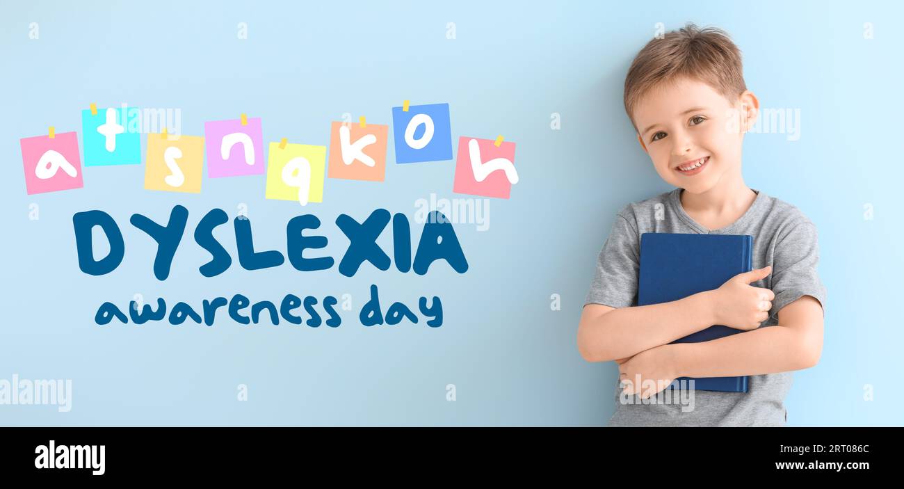 Little boy with book and text DYSLEXIA AWARENESS DAY on light blue