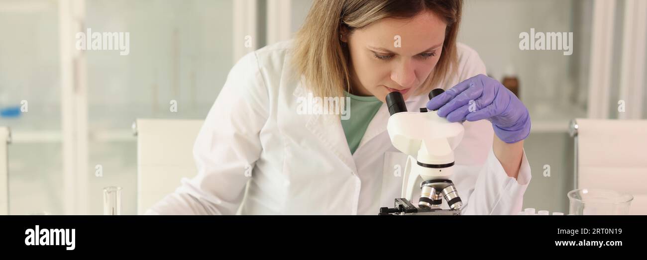 Female scientist with microscope, test tubes, laboratory glassware and ...
