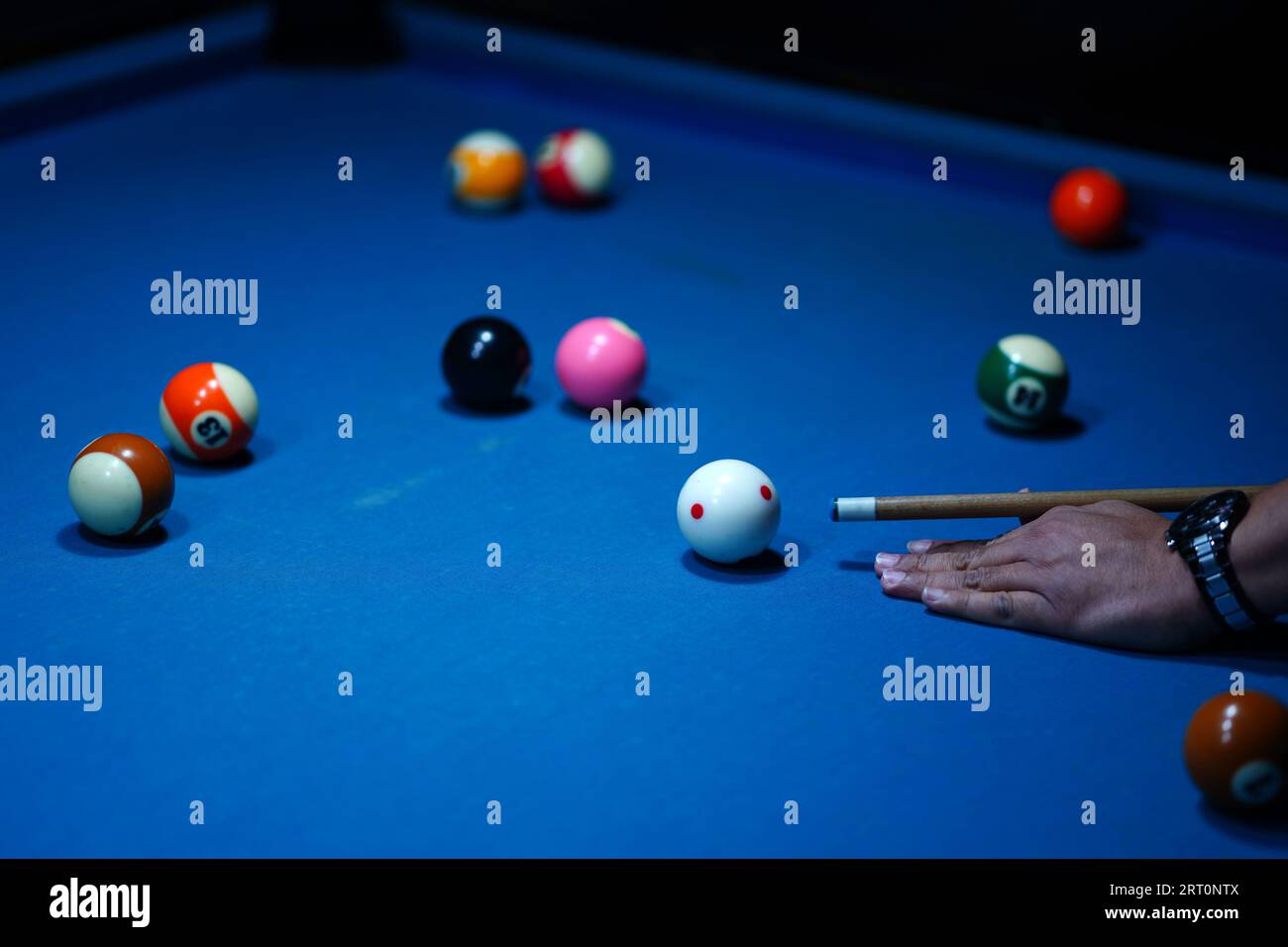 The hand holding the billiard cue, ready to make a precise strike on