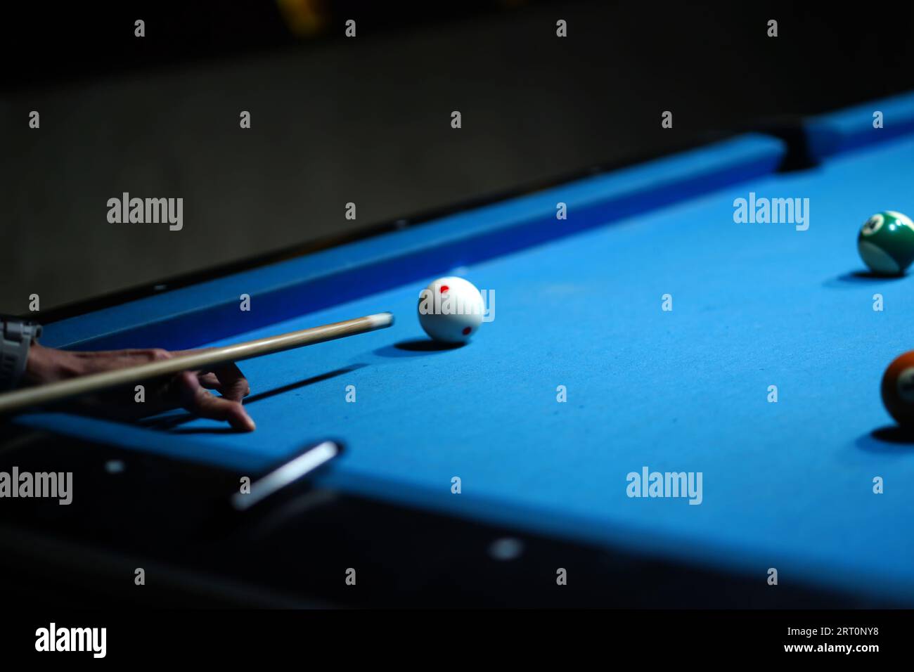 The hand holding the billiard cue, ready to make a precise strike on