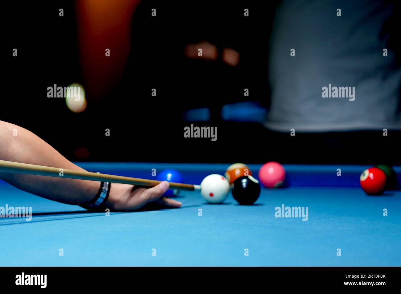 The hand holding the billiard cue, ready to make a precise strike on the billiard ball on the