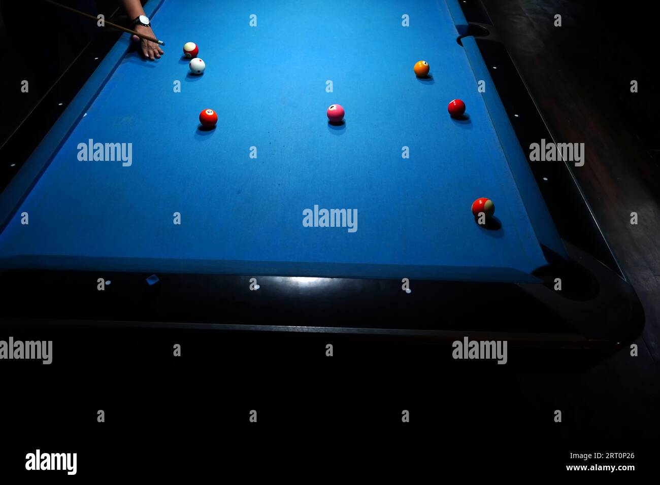 The hand holding the billiard cue, ready to make a precise strike on