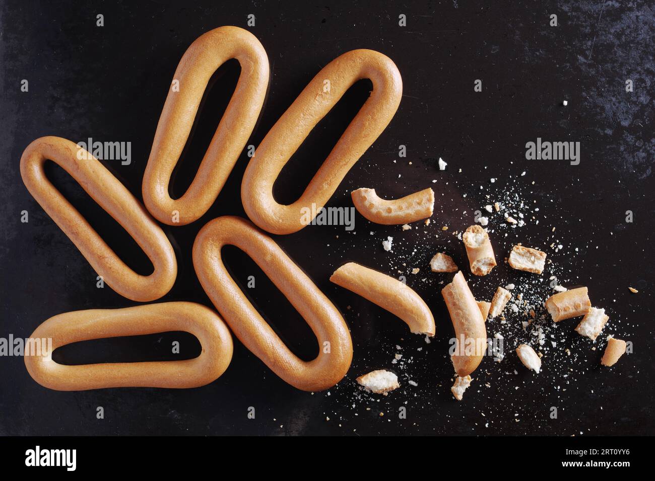 Oval bagels whole and broken on the old metal surface. Close up, top view Stock Photo