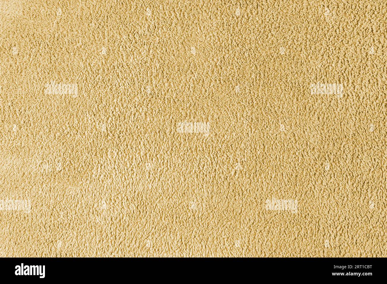 Terry cloth, yellow towel texture background. Soft fluffy textile bath or beach towel material. Top view, close up. Stock Photo