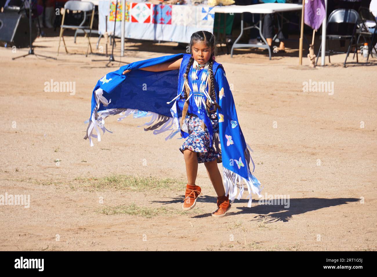 A young Native American dancer minds her steps as she competes in a shawl dance during a powwow on the San Xavier Reservation, near Tucson, Arizona. Stock Photo