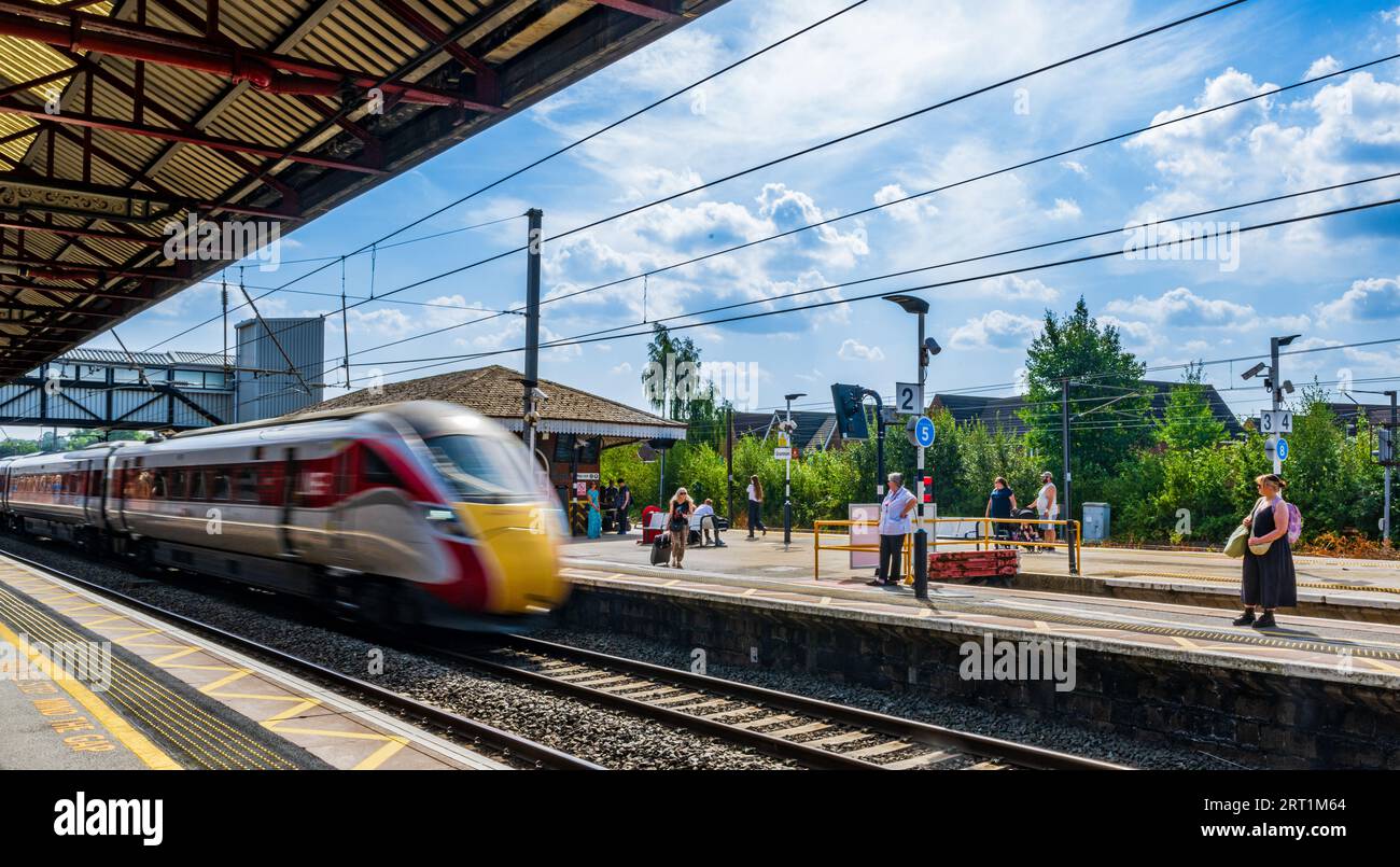 Grantham Rail Station – Passengers and travellers waiting on the platform on a summer day beneath a blue summer sky Stock Photo