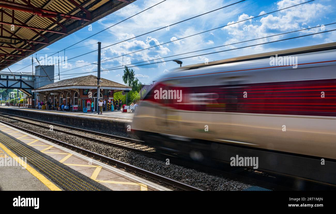 Grantham Rail Station – Passengers and travellers waiting on the platform on a summer day beneath a blue summer sky Stock Photo