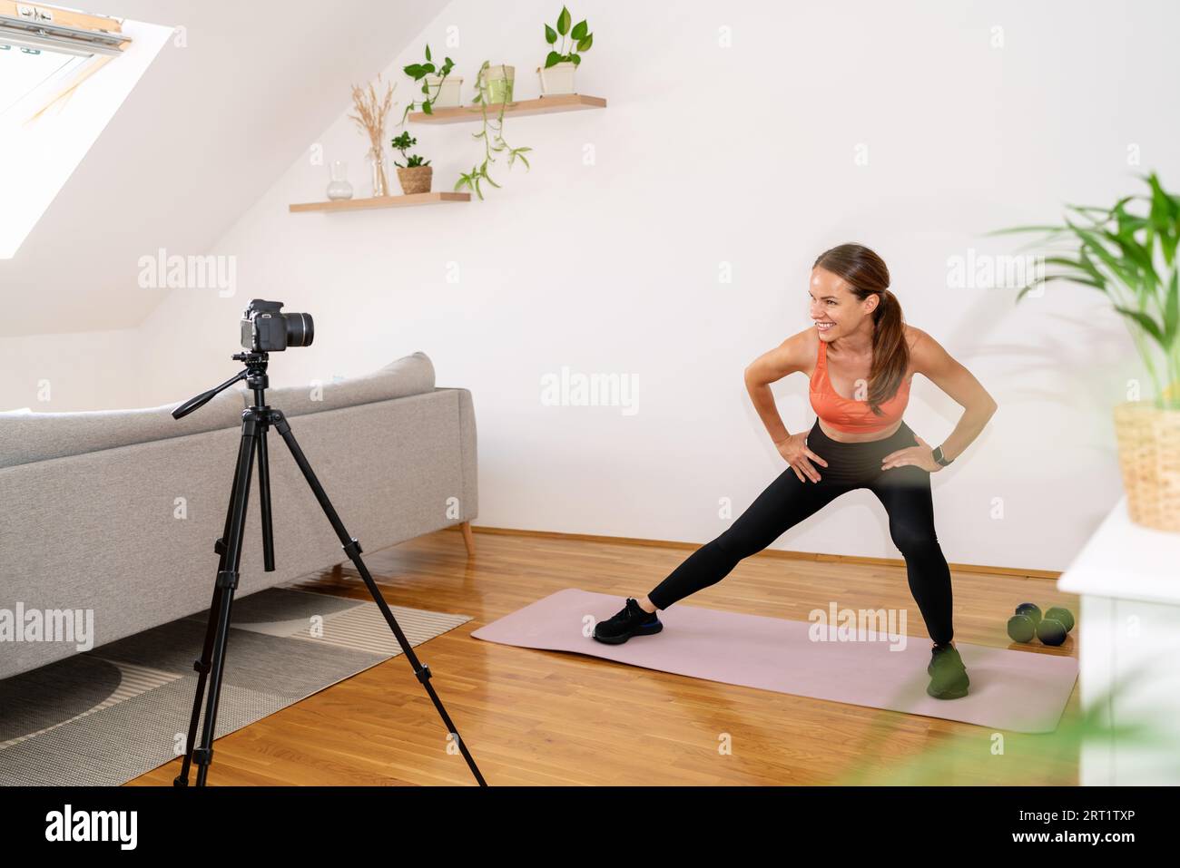 Athletic female online fitness coach vlogger recording video of sports