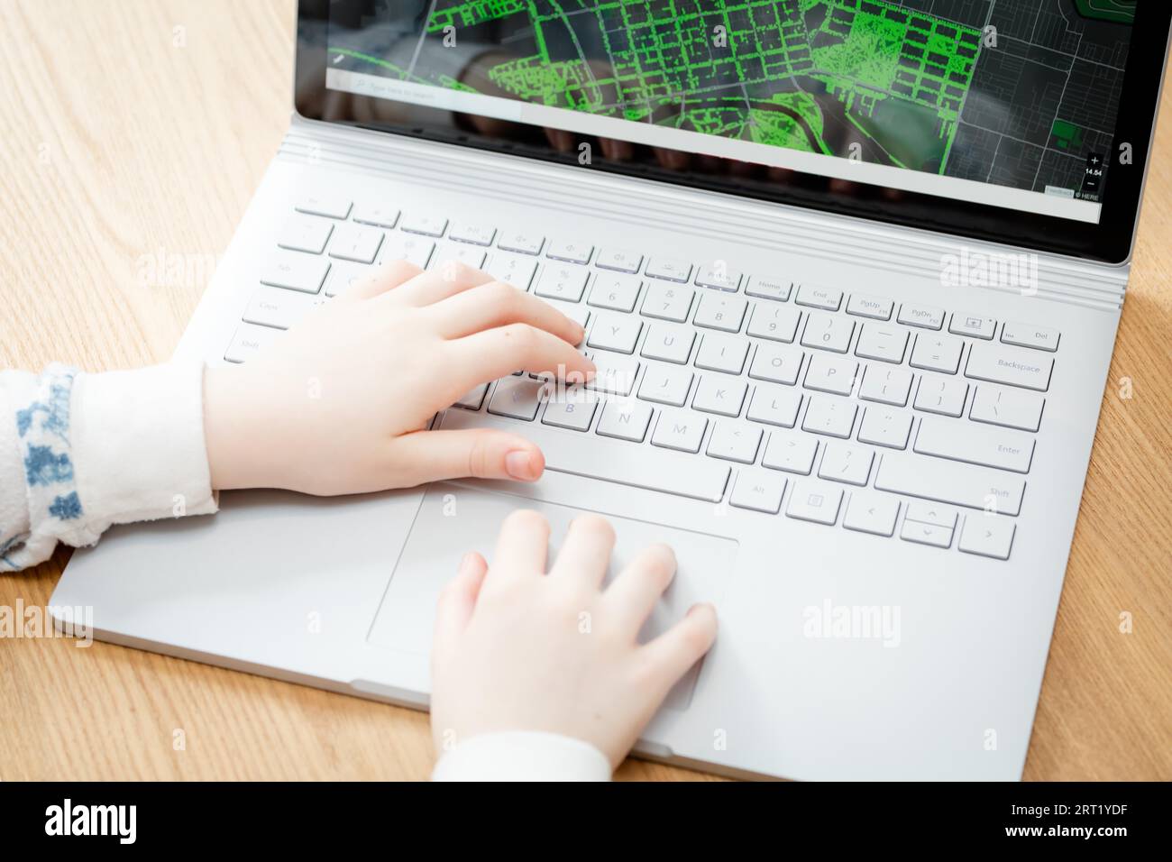 A young female child uses a computer in remote learning for her school ...