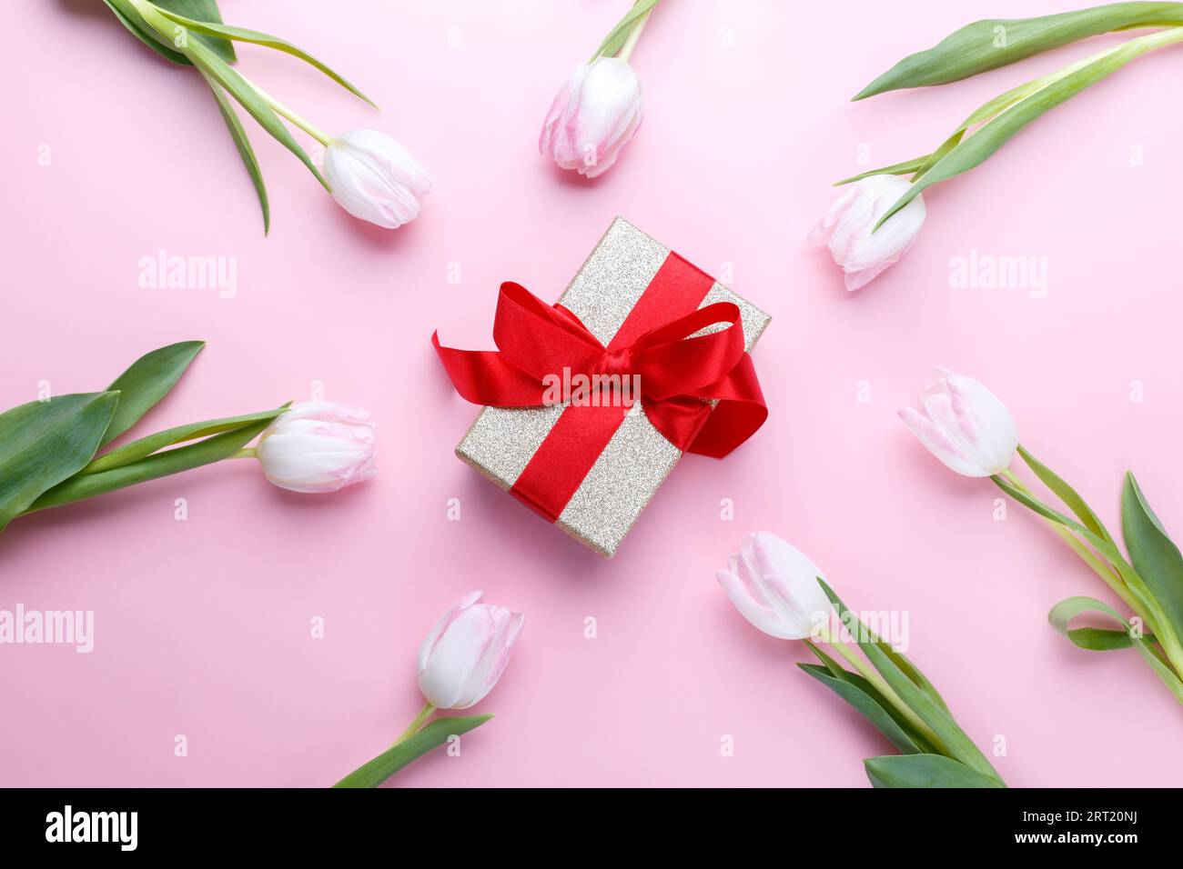 Tulips and gift box on pink background flat lay, romantic card template ...