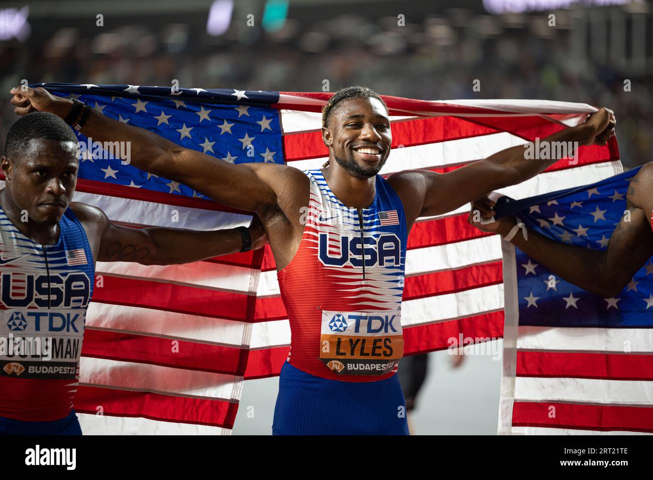 Noah Lyles celebrating her medal with her country's flag in the 4x100 m
