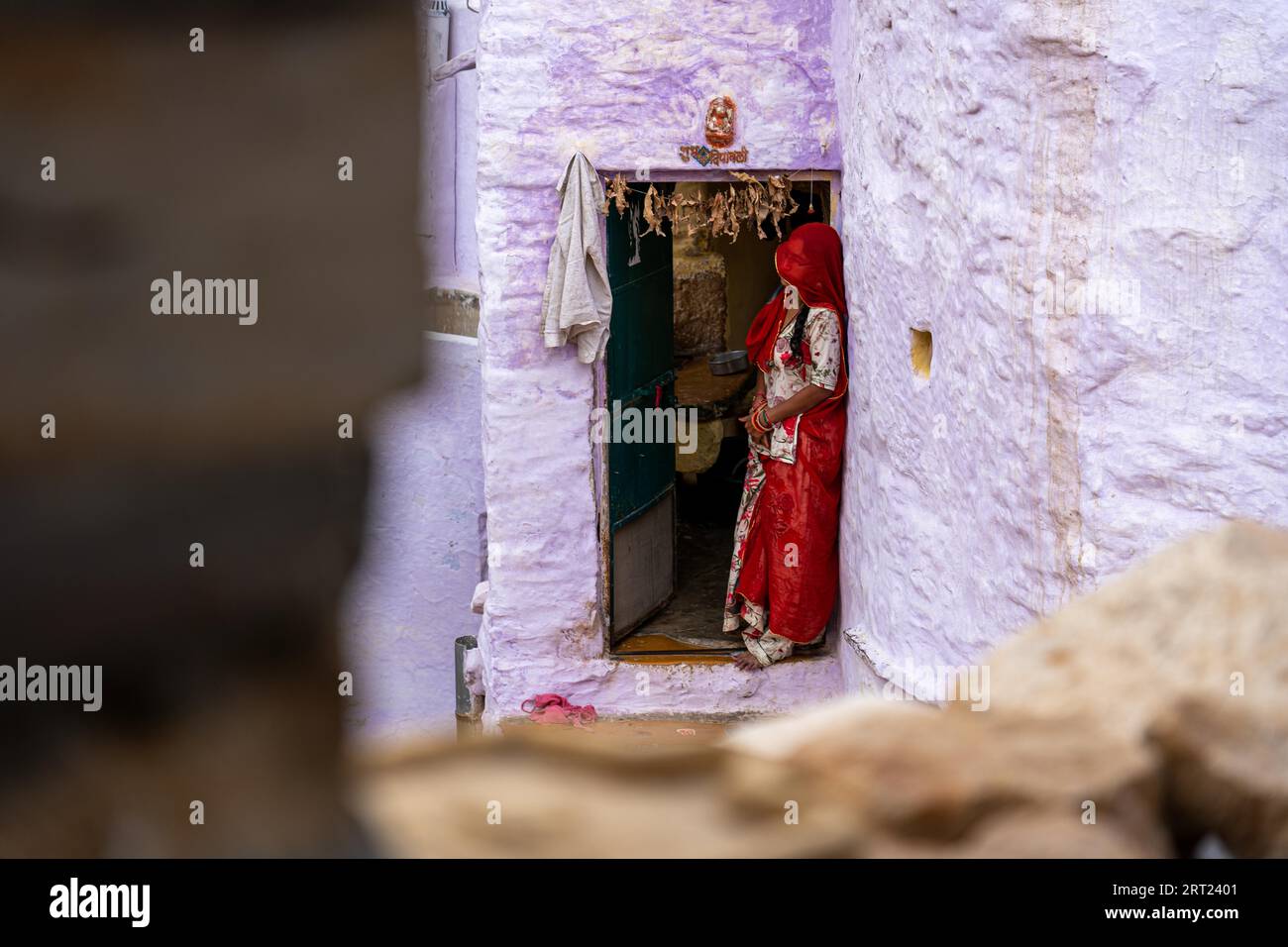 Jaisalemer, India, December 5, 2019: An Indian woman in colorful clothes standing in front her house Stock Photo