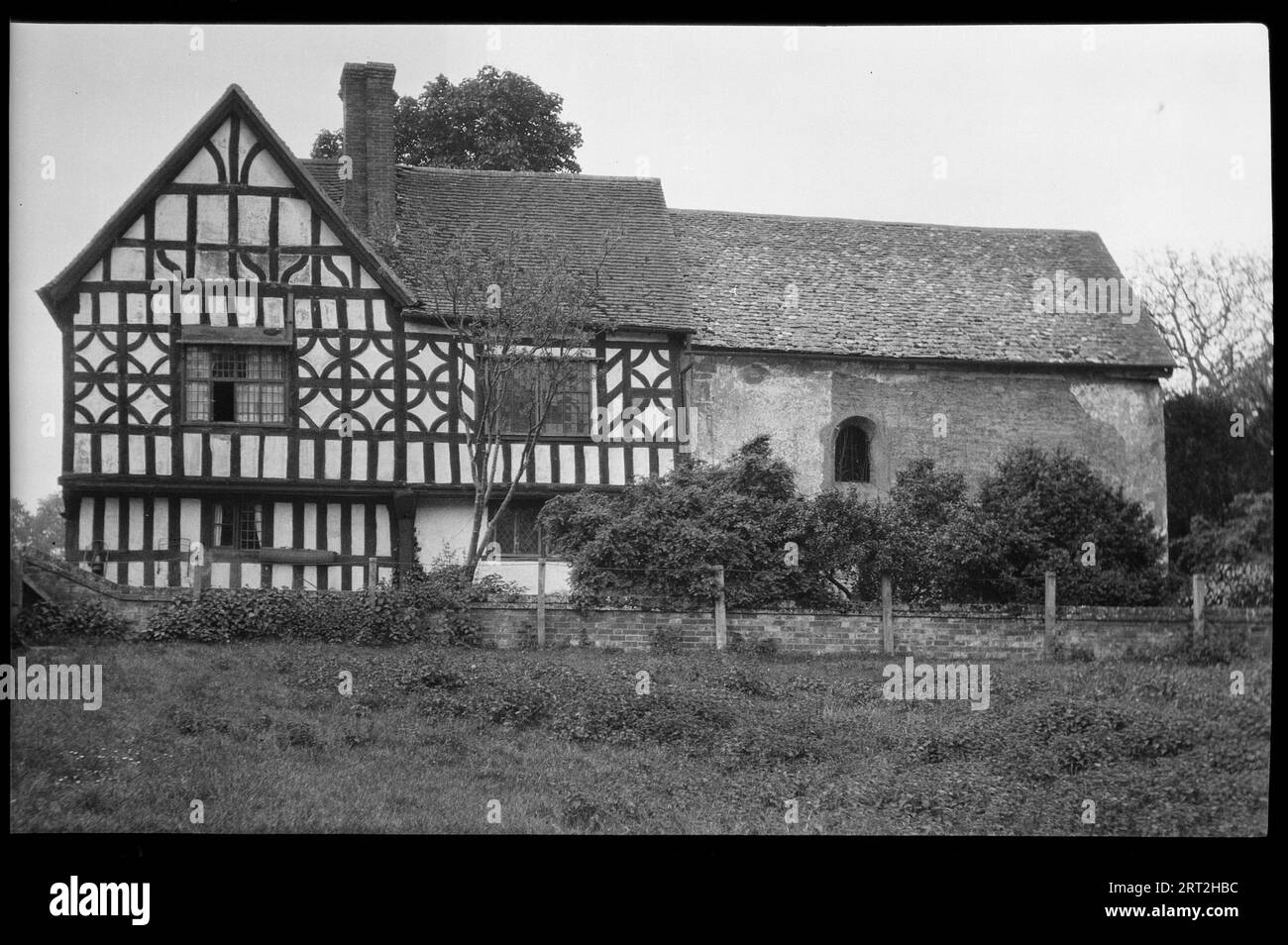 Odda's Chapel, Deerhurst, Tewkesbury, Gloucestershire, 1940-1949. External view of the north side of the chapel and farmhouse. The chapel dates to 1056 and was included in the building of the 17th century farmhouse, a timber framed house with rendered infill and a jettied first floor. Odda's Chapel was recognised in 1885 and fully disentangled from the house in 1965. The chapel is now looked after by English Heritage. Stock Photo