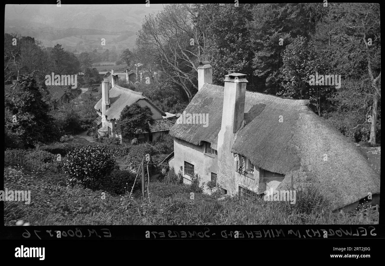 Selworthy, West Somerset, Somerset, 1940-1948. A view of thatched cottages, seen from the top of Selworthy and looking down at the rest of the village. The image shows the tops of buildings below the building in the foreground, which is most likely either the Periwinkle Tea Room, formerly listed as Cottage, or the Lorna Doone and National Trust Shop and Information Centre, formerly listed as two buildings; Lorna Doone and The Rest. Stock Photo