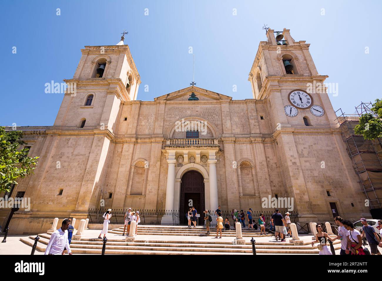Valletta, Malta - 17 June 2023: Facade of Valletta Cathedral and tourists on a sunny day, Malta. Stock Photo