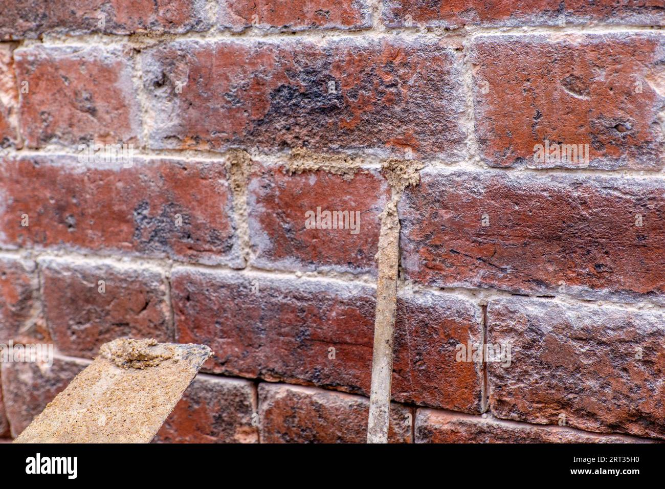 Pointing a brick house wall with traditional lime mortar Stock Photo