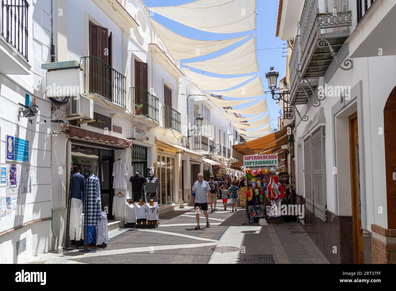Nerja, Spain, May 28, 2019: People walking in a charming narrow shopping street in the city centre Stock Photo
