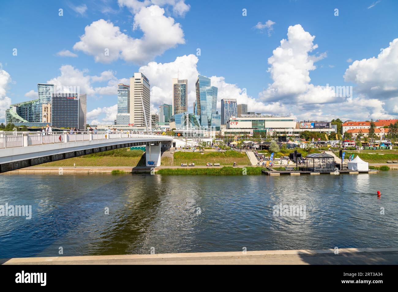 VILNIUS, LITHUANIA - 3RD SEPT 2023: A view across the Neris River showing the Baltasis tiltas bridge, lots of people and buildings. Stock Photo