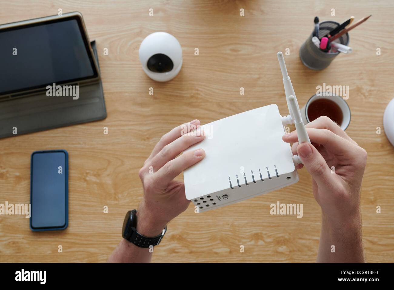 Hands of manager setting wi-fi router at his desk Stock Photo - Alamy