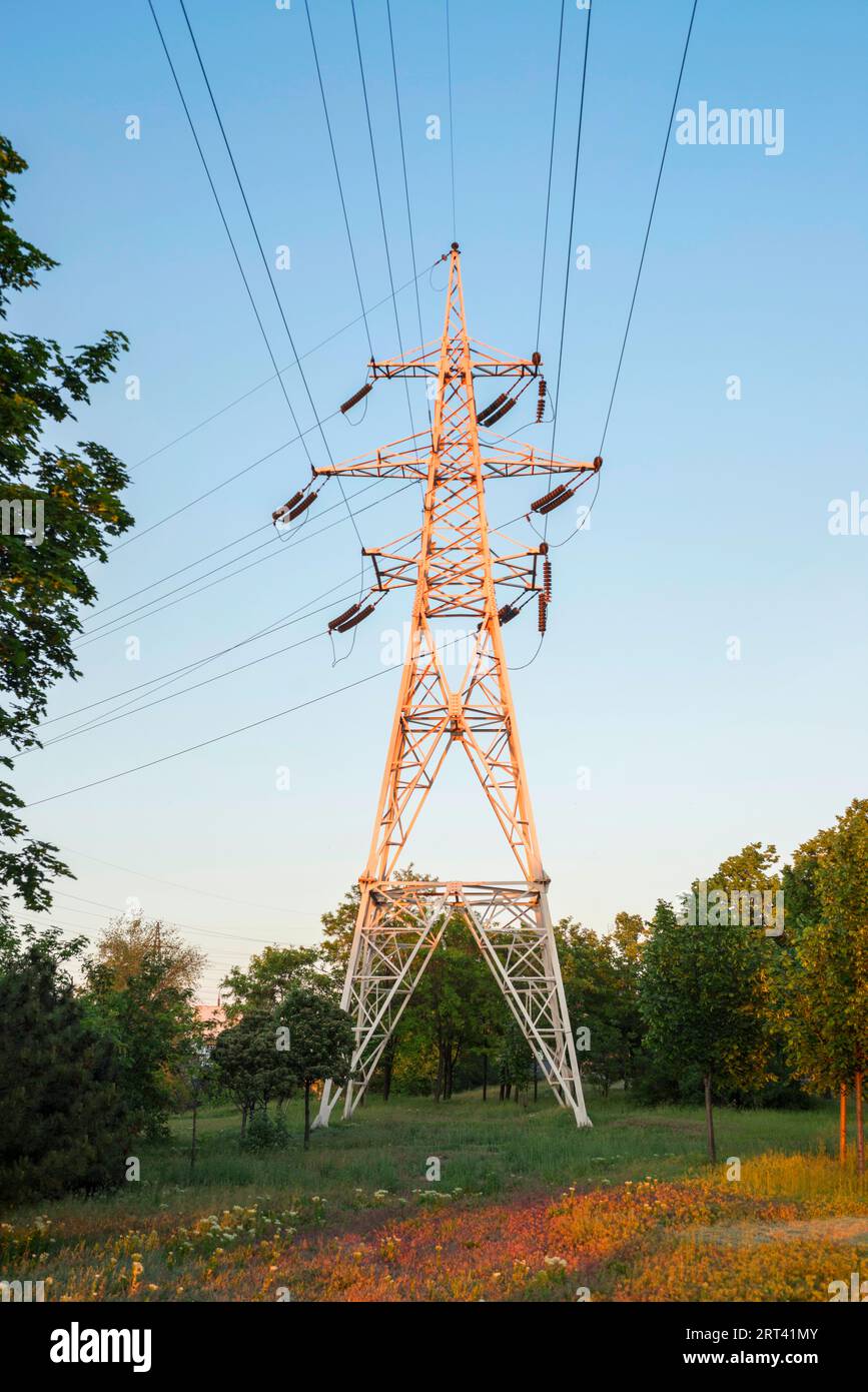 High voltage towers with electrical wires on dark cloudy sky background ...