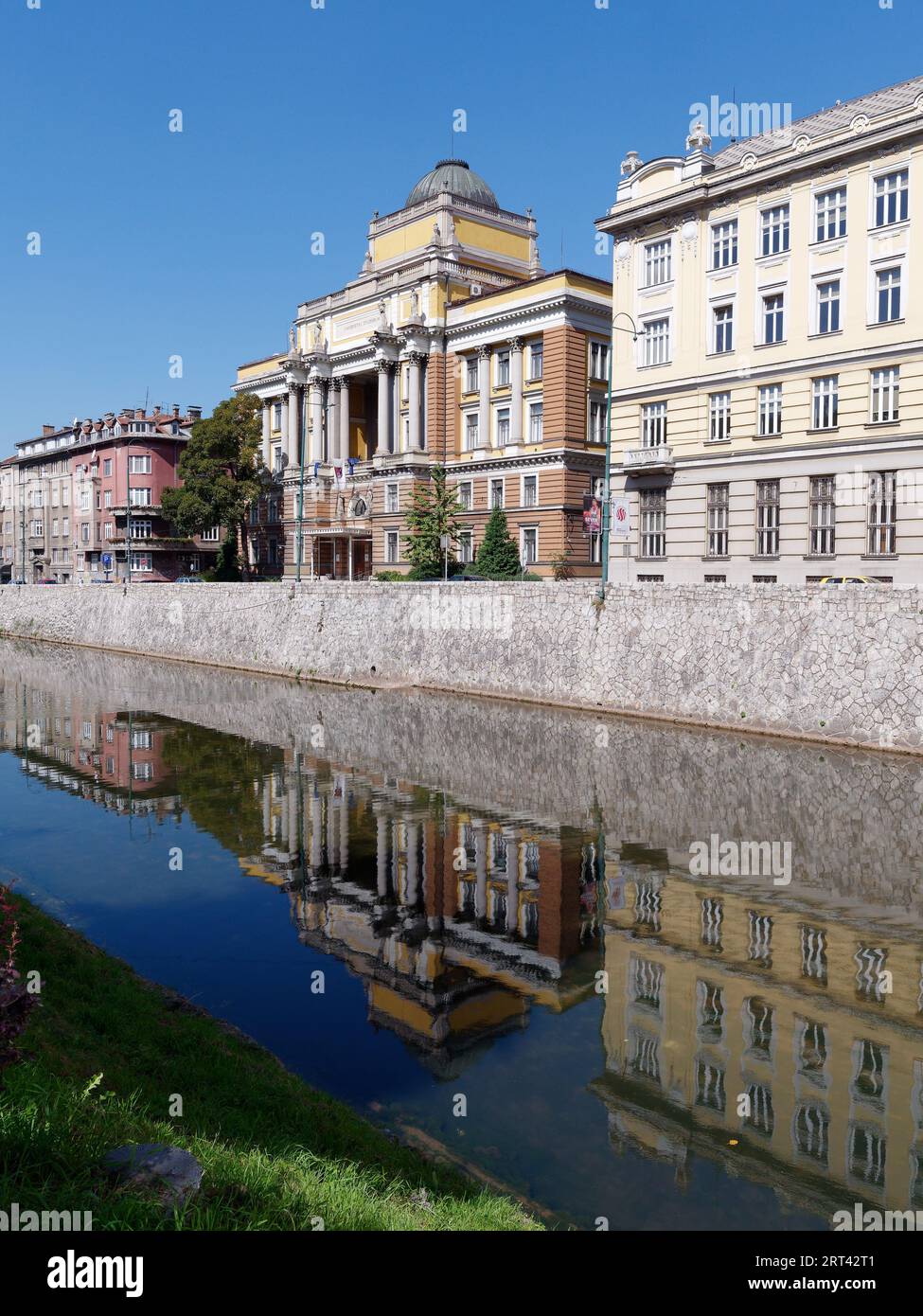 Elegant buildings along the River Miljacka reflected in the water  in the city of Sarajevo, Bosnia and Herzegovina, September 10, 2023 Stock Photo