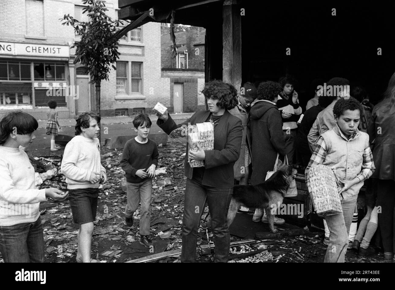 Toxteth Riots 1981 UK. Local children help them selves steal stuff from a shop that had been looted during the previous nights riots. Liverpool, Lancashire England circa July 1980s HOMER SYKES Stock Photo