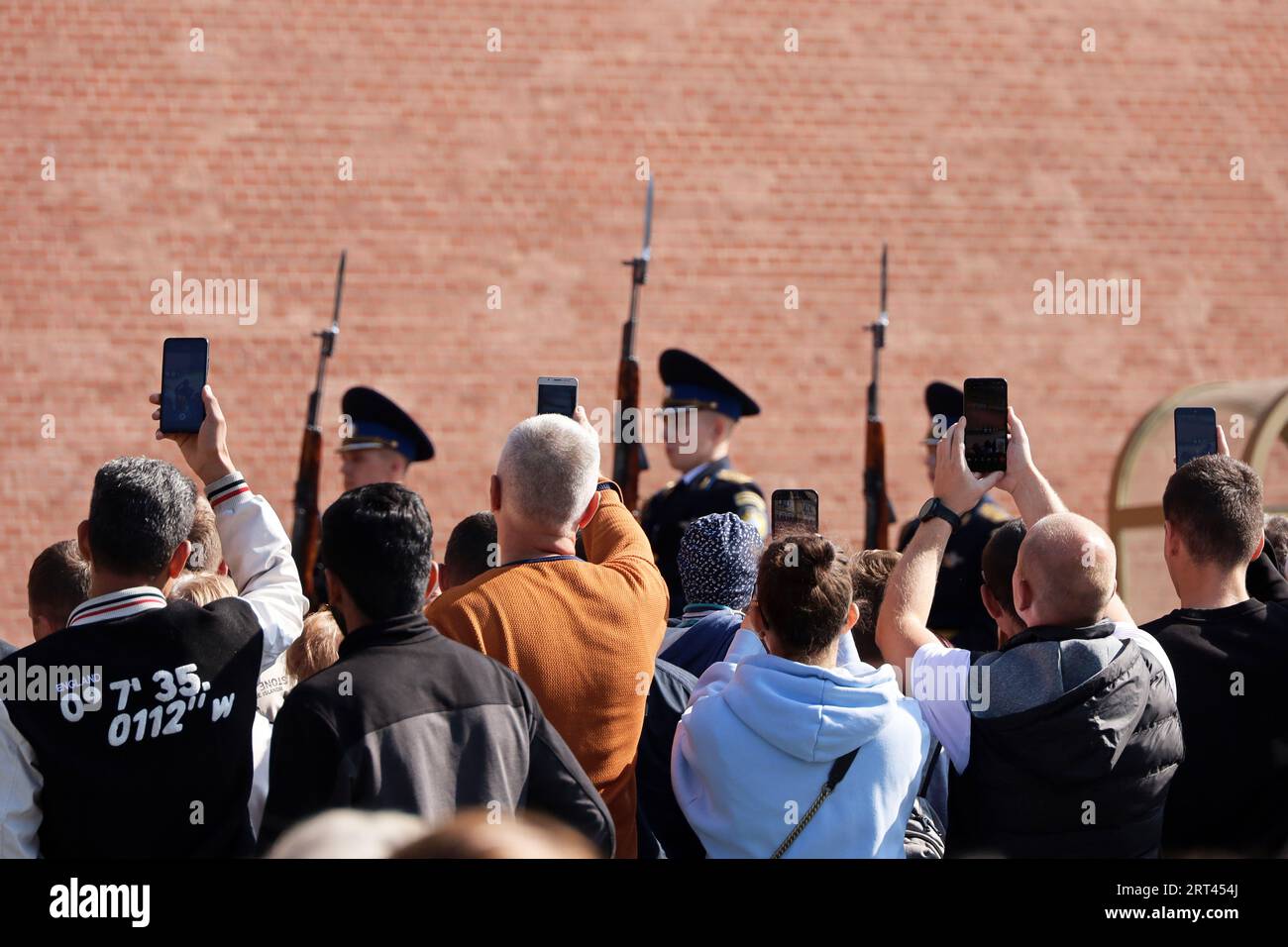 Tourists taking photo on smartphones of Russian soldiers on march near the Kremlin wall. Change of the honor guard of the Presidential regiment Stock Photo