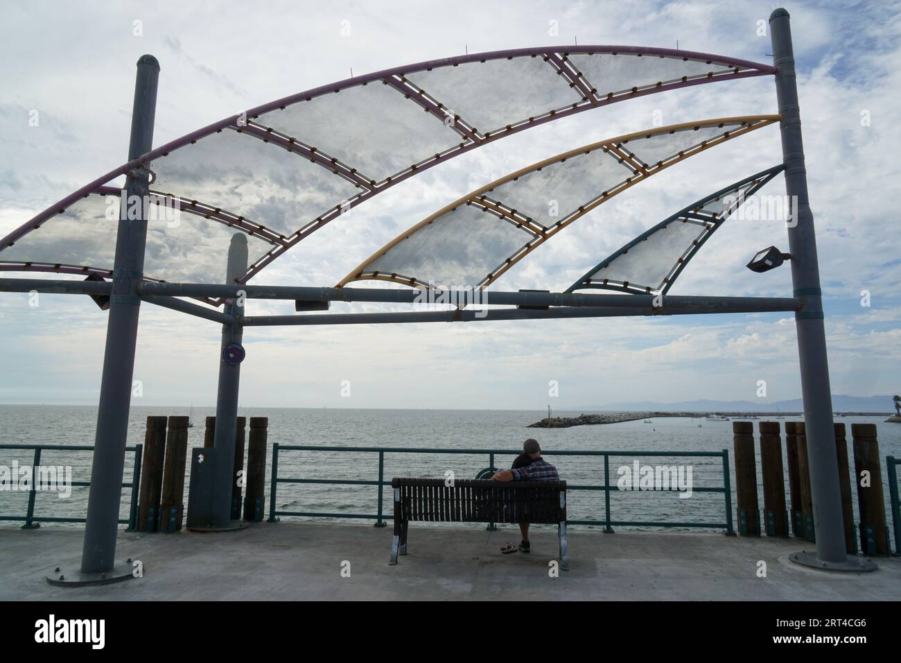 A couple sits on a beach and looks out at the ocean Stock Photo - Alamy